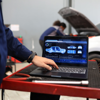 An overhead image of two people talking beside two new cars in a showroom.